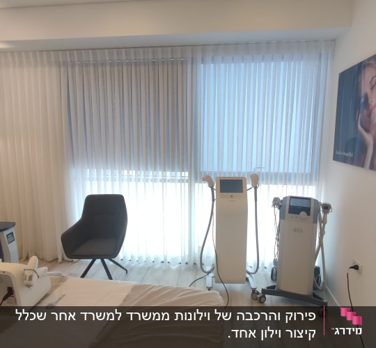 וילון לבן ארוך מכסה חלון גדול בחדר טיפולים